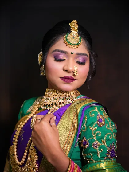A photo of a student's work on a Maharashtrian bride, showcasing a beautiful purple and green saree look.