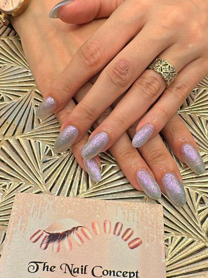 Long, stiletto-shaped nails with a mesmerizing lavender holographic glitter finish. These nails shift in color and sparkle intensely with every movement.