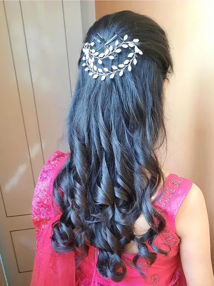 Simple and elegant curls held back with a silver leaf-themed hair clip. This is a timeless look that suits any outfit.