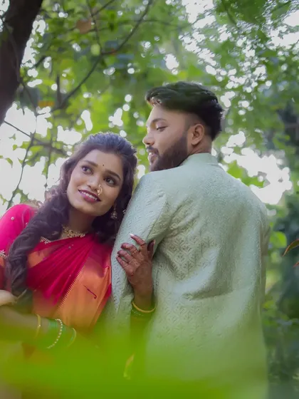 A beautifully framed shot of the couple through the leaves, creating a sense of intimacy and a private moment shared just between them.