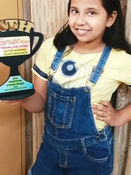 This is what it's all about. A proud winner holding her 'Outstanding Performance' trophy. I make sure our winners receive these beautiful awards to celebrate their achievement.