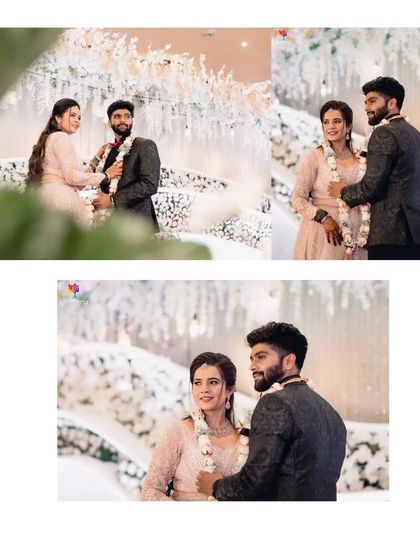 A candid moment during the garland exchange at a reception. The couple's smiles and the beautiful white floral decor create a picture of pure happiness.