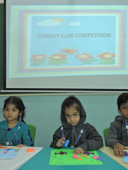 Students are seated and ready for the 'Clayazy' clay modeling competition, with their materials prepared for an afternoon of creativity.