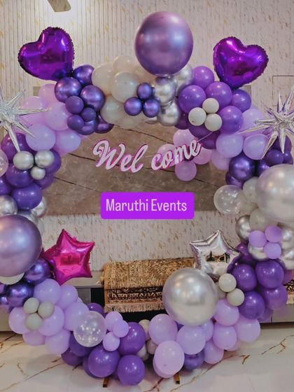A purple and silver 'Welcome' balloon ring, perfect for a stylish baby shower or homecoming party.