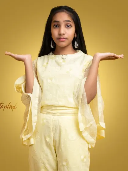 A stylish portrait of a young girl in a fashionable yellow outfit. The warm, gradient background and her confident pose give this image a polished, editorial feel suitable for youth fashion.