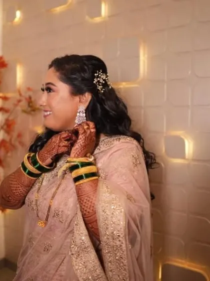 A candid shot of the bride getting ready for her reception. The soft curls and delicate hair accessory add a touch of sparkle to her look.