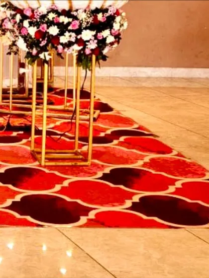 The aisle leading to the cradle, lined with tall golden stands and floral arrangements, creating a grand pathway.
