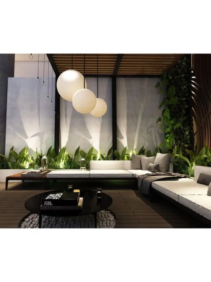 A cozy corner of the terrace lounge, surrounded by a lush green wall and illuminated by modern spherical pendant lights.