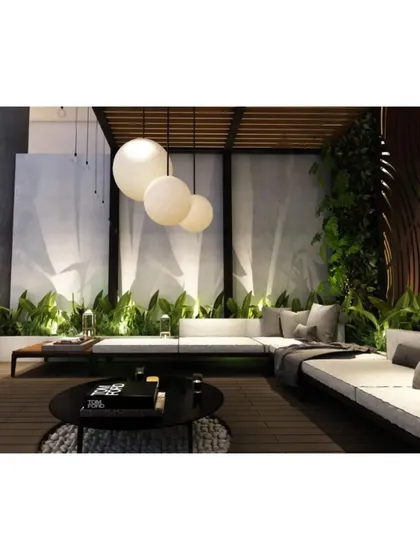 A cozy corner of the terrace lounge, surrounded by a lush green wall and illuminated by modern spherical pendant lights.