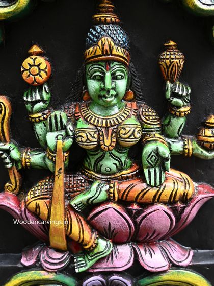 Detail of Dhanya Lakshmi from the vertical Astalakshmi panel, painted in a serene green, holding sheaves of paddy.