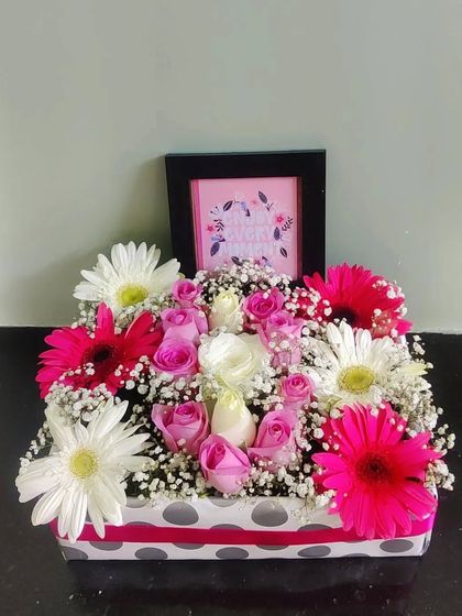 A personalized floral box featuring a mix of pink gerberas and roses, with a small framed picture nestled in the center. It’s a wonderful way to combine a photo gift with fresh flowers.