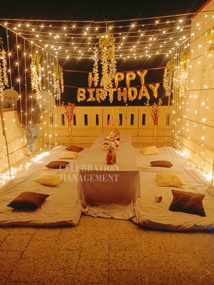 The warm glow from the fairy lights creates a beautiful ambiance, perfect for a memorable birthday evening with friends.