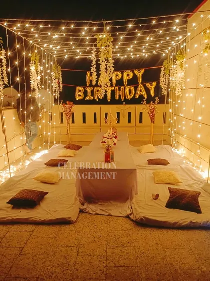The warm glow from the fairy lights creates a beautiful ambiance, perfect for a memorable birthday evening with friends.
