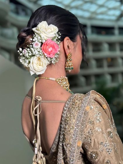 A beautiful rose bun featuring a mix of white and pink roses. This hairstyle is perfect for a bride who wants a romantic and feminine look.