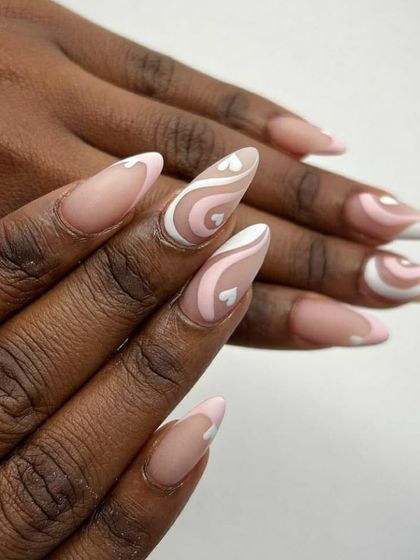 A romantic and trendy design with a matte finish. This look combines swirls of pink and white with tiny heart details on almond-shaped nails.