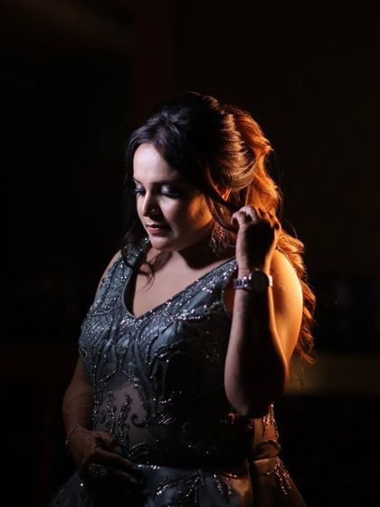 A beautifully lit portrait of the bride Gunjan. The warm light from the side creates a gentle glow, highlighting her features and the texture of her gown in this thoughtful pose.