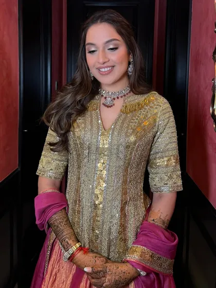 A happy bride twirling in her Mehendi outfit, her hair styled in soft, flowing waves.