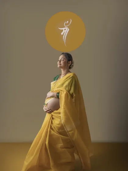 A serene solo portrait of the mother to be in her yellow saree, eyes closed in peaceful contemplation. The 'Maa' symbol above her head beautifully completes this tribute to motherhood.