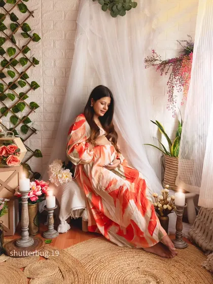 A quiet moment of reflection in our cozy, bohemian-styled studio setup. Surrounded by soft candlelight and natural textures, the mom-to-be cradles her bump, creating a warm, intimate, and beautifully serene maternity portrait.
