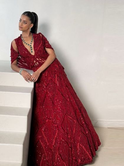 A full-length view of the embellished red bridal gown, showcasing its voluminous skirt and detailed craftsmanship, designed to make an unforgettable statement.