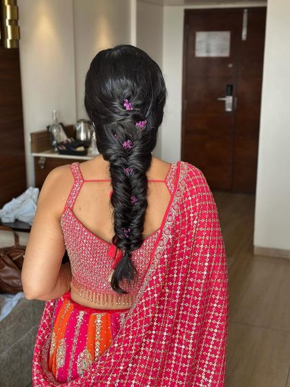 A simple fishtail braid can be elevated with a few carefully placed floral accents. Here, I used small purple flowers for a subtle pop of color.