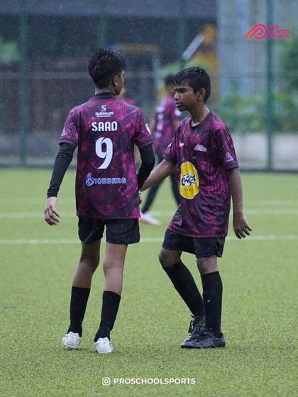 A moment of communication and teamwork between two players during a rainy match.