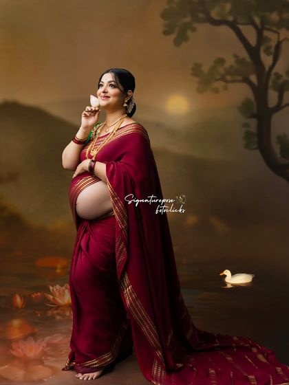 A dreamy, artistic portrait with a painted lake backdrop, where the mother holds a lotus flower.