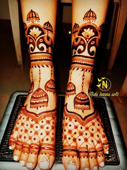 This unique bridal feet design features hanging jhumkas (earrings) and elephant motifs. It's a playful and traditional style that looks stunning.