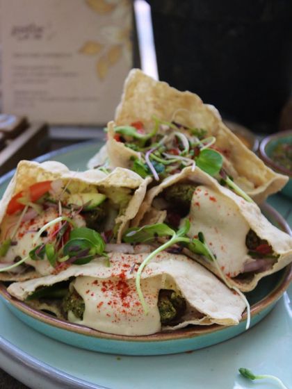 A close-up of our stuffed pita pockets, brimming with fresh salad and savory falafel. It's a plate packed with both intense flavor and nutrition.