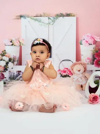 Pretty in pink for her very first birthday. This sweet and simple setup uses a clean background and an abundance of pink flowers to create a delicate and feminine portrait for her special day.