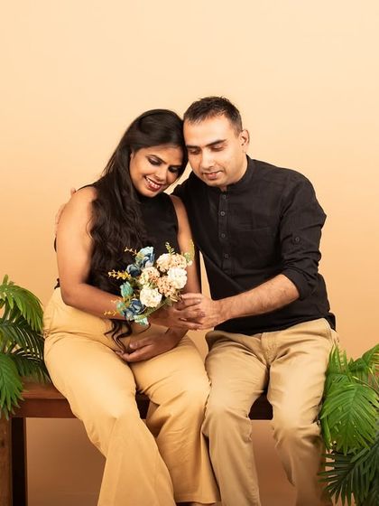 A quiet, shared moment during a studio maternity session. The simple setup with minimal props allows the couple's loving connection to be the main focus.