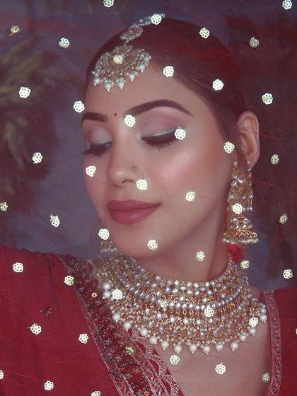 A classic red bride look is always in demand. This look features a modern twist with a sharp green winged liner, paired with traditional red attire and gold jewelry.