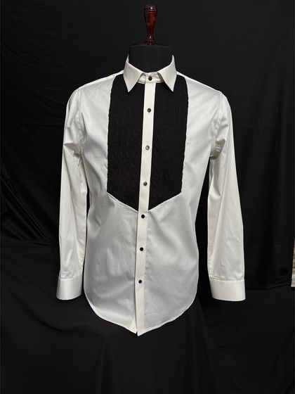 This is my classic white tuxedo shirt featuring a contrasting black textured bib. The meticulous pleating and sharp collar provide a clean and sophisticated base for any tuxedo jacket.