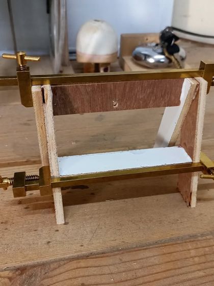 A different view of the miniature chair being clamped during assembly. These brass clamps provide gentle, precise pressure perfect for delicate model work.