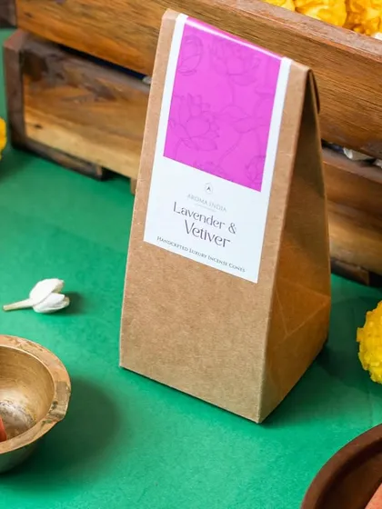 Our Lavender & Vetiver incense cones, shown here with a traditional brass burner and marigold flowers. The calming aroma is inspired by nature and perfect for creating a tranquil environment.