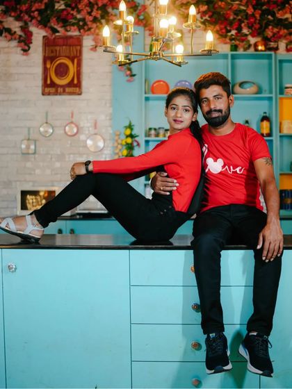 A couple sits on the counter of our colorful kitchen set, a fun and modern pose.