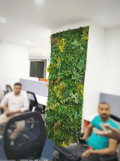 This artificial green wall acts as a natural-looking divider in an open-plan office. It helps to break up the space while adding a refreshing visual element that can improve the work environment.