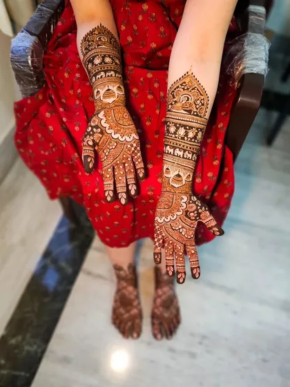 A full view showing the bride's intricate hand and feet henna, creating a complete and cohesive bridal look.