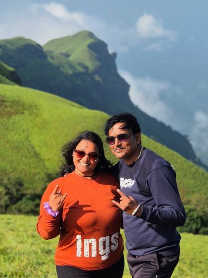 A couple having fun on the Bandaje trail, with the beautiful green hills behind them.