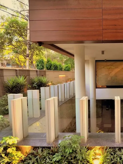 Timeless elegance meets modern design. This detail shot shows the unique void that serves as a courtyard to the basement, surrounded by lush greenery and illuminated stone pillars.