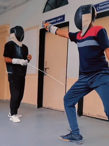 A fencer executes a clean attack during a practice match. Notice the extended arm and forward lunge, aimed at scoring a touch on the opponent.