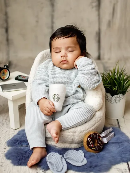 A humorous take on a sleepy baby. This creative "office nap" setup is a fun way to capture a baby's sleepy side during a milestone photoshoot.
