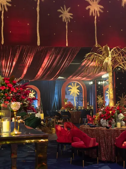 This area of the speakeasy had a slightly different feel, with a 'Midnight in the Oasis' theme. I used golden palm tree motifs, deep red velvet, and starry ceiling drapes to create a sense of exotic glamour.