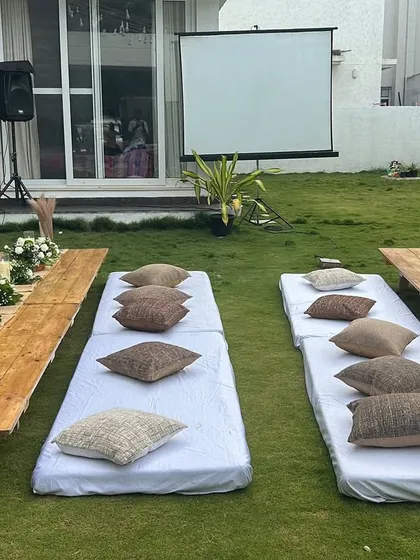 A clear view of the low seating arrangement for the movie night party, with mattresses, cushions, and low wooden tables.