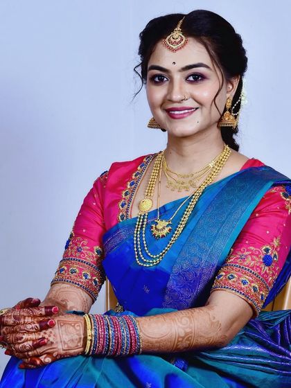 A beautiful portrait of a client ready for her ceremony. The makeup is classic and elegant, designed to enhance her features and complement the vibrant colors of her saree.