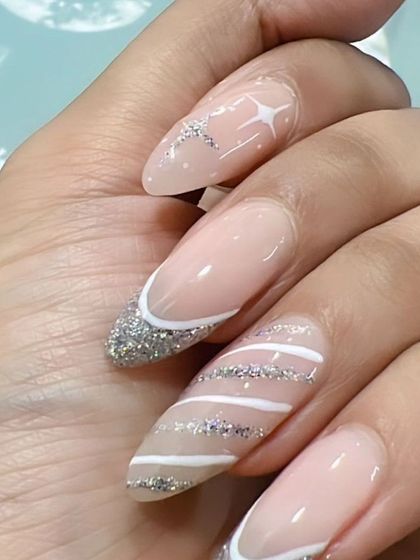This almond-shaped set features a mix of silver glitter French tips, striped patterns, and delicate star details.