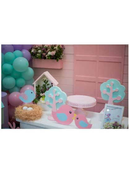 A dessert table from the birdhouse party, with cute bird cutouts, a mini birdhouse, and a nest with eggs.