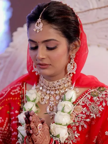 A serene moment of prayer during the wedding ceremony. Her soft glam makeup, with its warm tones and gentle shimmer, looks elegant and timeless, perfectly suited for the solemnity and joy of the occasion.