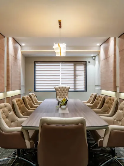 The main conference room, designed for formal meetings. The tufted chairs and wood-paneled walls create a sense of classic luxury and professionalism.