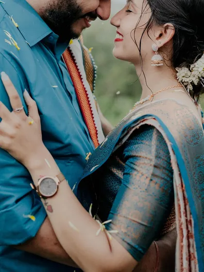 A close-up filled with emotion and joy. The flower petals showering down on them add a touch of magic to this intimate moment during their Alibag pre-wedding shoot.